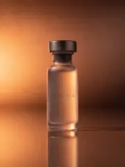 Glutathione vial with GLUTATHIONE imprint against a dark bronze sunrise gradient