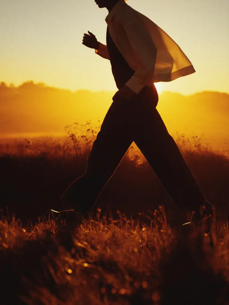A walker on a warm-lit path at sunrise, steady and energized