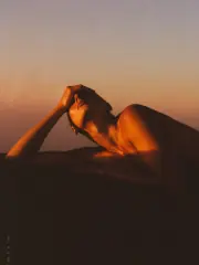 A figure cresting a hill trail at sunrise, recovered and strong
