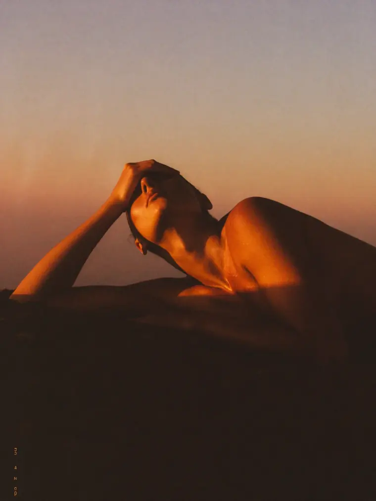 A figure cresting a hill trail at sunrise, recovered and strong